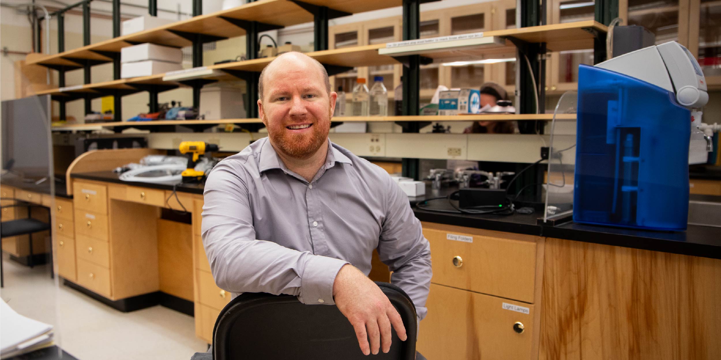 Professor Jimmy Dolley sitting on a chair in his lab